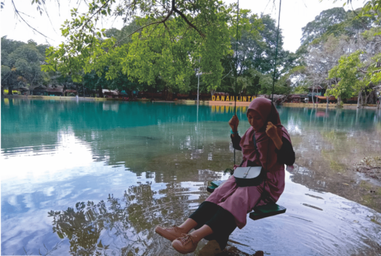Pengunjung bermain ayunan di tepi danau Arif Setiawan 1024x688 1 768x516 1