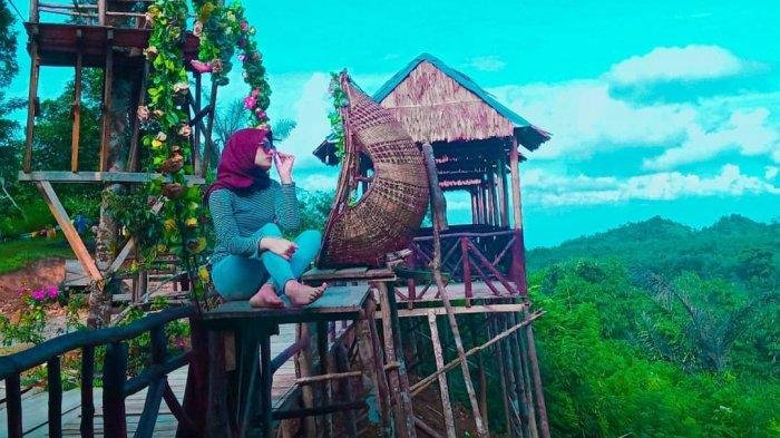 pengunjung berfoto di rumah pohon puncak adem 1