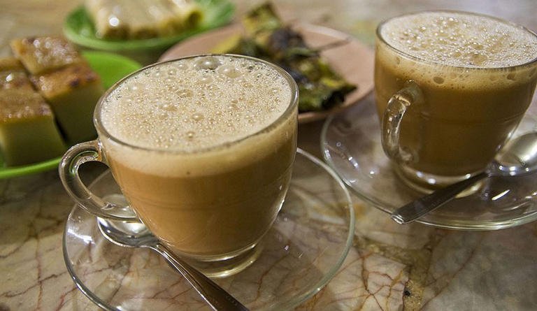 Aceh merupakan wilayah yang menarik untuk dikunjungi. Selain karena warisan budaya pakaian adat, tarian adat dan lain sebagainya yang sangat menarik, Aceh juga memiliki daya tarik tersendiri di bidang kulinernya. Ilustrasi, Kopi Sanger. Ilustrasi, Kopi Sanger. © Dok. Dinas Kebudayaan dan Pariwisata Aceh Jika Anda mendengar kuliner asal Aceh, pasti yang terlintas di pikiran adalah hidangan Mie Aceh yang sudah melegenda, dan tersebar pula di berbagai tempat di Indonesia. Sie Reuboh, Keumamah, Ie Bu Peudah, dan masih banyak lagi kuliner makanan khas Aceh yang terkenal. Namun, suguhan dari "Tanah Rencong" ini tak melulu soal makanan, melainkan juga minumannya. Bicara soal minuman khas Aceh, tentu tidak lepas dari pembicaraan terkait kopi. Ini tidak mengherankan, sebab Aceh merupakan salah satu daerah penghasil kopi terbaik Indonesia. Meski demikian, ragam minuman yang berasal dari Aceh tidak hanya didominasi oleh minuman berbasis kopi saja. Untuk memahami lebih lanjut, berikut ini penjelasan mengenai minuman khas Aceh selengkapnya. Baca Juga 6 Makanan Khas Aceh dengan Cita Rasa Istimewa 1. Kopi Gayo Kopi Gayo merupakan minuman khas Aceh yang sangat terkenal di Indonesia. Minuman khas Aceh ini terbuat dari biji kopi yang berasal dari dataran tinggi Gayo. Biji kopi ini telah ada sejak jaman pendudukan Belanda. Banyak kedai yang menjual Kopi Gayo sehingga jika ingin mencicipi pun mudah. 2. Kopi Sanger Kopi Sanger adalah salah satu minuman khas Aceh yang unik. Minuman ini merupakan campuran dari kopi hitam, gula yang diseduh air panas serta susu kental manis. Rasa kopi yang nikmat dipadu dengan gula dan susu kental manis membuat rasa kopi tidak terlalu pahit. Paduan tersebut kemudian disaring dengan saringan yang berbentuk kerucut. Pengolahan yang masih menggunakan cara tradisional itu menjadi cita rasa khas Kopi Sanger. 3. Kopi Kurma Minuman khas Aceh selanjutnya, adalah Kopi Kurma. Minuman ini terbuat dari kopi Arabika yang dihaluskan, yang dicampur susu, kurma, dan madu segar kemudian diseduh dengan air panas. Kopi Kurma menyajikan rasa unik, karena kopi bisa berpadu dengan manisnya susu, kurma, dan madu segar. Bagi wisatawan yang berkunjung ke Aceh, maka wajib mencicipi Kopi Kurma ini. 4. Teh Tarik Teh tarik ini terbuat dari susu kental manis, teh, dan gula. Minuman khas Aceh ini telah dikenal di berbagai daerah di Indonesia. Cara pembuatannya sangat khas yakni dengan menuangkan campuran tersebut secara bolak balik. Cara pembuatan minuman ini membuat adanya busa yang memberikan sensasi lembut saat diminum. Teh Tarik tak asing lagi bagi masyarakat Indonesia. Nikmatnya teh hangat yang dicampur gurihnya susu membuatnya semakin menarik dicoba. 5. Ie Seureubet Ie Seureubet merupakan salah satu minuman khas Aceh yang unik. Minuman ini dibuat dari aneka rempah-rempah yang khas seperti lada, kayu manis, jahe, dan rempah-rempah lainnya. Campuran rempah-rempah tersebut membuat hidangan ini terasa hangat di tubuh. Rasanya sedikit pedas dan menyegarkan dengan aroma khas rempah-rempah yang menenangkan akan menjadi hidangan sempurna saat berkunjung ke Aceh. 6. Le Boh Timon Minuman khas Aceh yang menyegarkan salah satunya yakni Le Boh Timon. Minuman ini terbuat dari es timun serut. Pada umumnya, Le Boh Timon dikonsumsi oleh Warga Aceh saat bulan Ramadhan. Namun tak menutup kemungkinan Le Boh Timon dapat dikonsumsi kapan saja. Minuman ini terbuat dari serutan timun yang dicampur dengan sirup gula serta es batu. Minuman ini juga terkadang dicampur dengan biji selasih. Kesegaran Le Boh Timon dapat diperoleh saat berkunjung ke Aceh dengan mudah. Berbagai sudut wilayah Aceh pun menyajikan hidangan ini dengan harga terjangkau. 7. Susu Jahe Minuman khas Aceh yang populer di Indonesia ini mampu menyehatkan tubuh. Susu Jahe terkenal di Tanah Rencong hingga sepanjang Pulau Jawa. Minuman khas Aceh ini dulunya hadir dengan geoukan jahe segar yang menyehatkan dan dicampur dengan susu. Seiring dengan berkembangnya jaman, kini hadir Susu Jahe dalam bentuk bubuk. Cara membuatnya mirip seperti Bandrek. Namun, bahan utamanya adalah susu dan Jahe saja. Minuman ini kerap hadir hangat daripada es. Nikmatnya susu berpadu dengan jahe membuat badan hangat dan segar. 8. Kupi Khop Minuman khas Aceh yang berkaitan dengan kopi adalah Kupi Khop. Cara penyajiannya yang unik pun menjadi ciri khas hidangan ini. Minuman ini terbuat dari campuran kopi rabusta dan gula. Terkadang untuk menambah cita rasanya, minuman ini ditambahkan susu. Kopi Khop disajikan dengan gelas terbalik yang diletakkan di atas pirong. Sajian ini berbeda dengan kopi pada umumnya. Inilah yang menjadi ciri khas Kopi Khop. Tak hanya cara penyajiannya saja yang unik, cara meminumnya juga menarik. Minumlah Kupi Khop ini dengan sedotan agar semakin terasa nuansa khasnya. 9. U Muda Teu Teot U Muda Teu Teot merupakan nama lain dari Kelapa Bakar. Minuman khas Aceh yang memiliki nama menarik ini termasuk minuman yang menyehatkan. Tak hanya menghadirkan kesegaran kelapa saja. Minuman ini juga dipadukan dengan rempah-rempah lainnya. Rempah-rempah tersebut dapat menghangatkan tubuh. 10. Es Tebu Siapa yang menyangka bahwa Es Tebu berasal dari Aceh. Nama lain minuman khas Aceh ini adalah le Tubr. Es Tebu sangat mudah ditemukan di Aceh. Banyak pedagang yang menjualnya di tempat makan maupun para pedagang kaki lima. Minuman sehat dan menyegarkan tak lagi harus diperoleh dengan harga tinggi. Rasanya segar dan menyehatkan dapat diperoleh dengan harga yang sangat terjangkau. Demikian penjelasan terkait dengan minuman khas Aceh yang nikmat dan menyegarkan. Jika berwisata ke Aceh, tentu wajib mencicipi minuman khas Aceh agar perjalanan semakin sempurna.